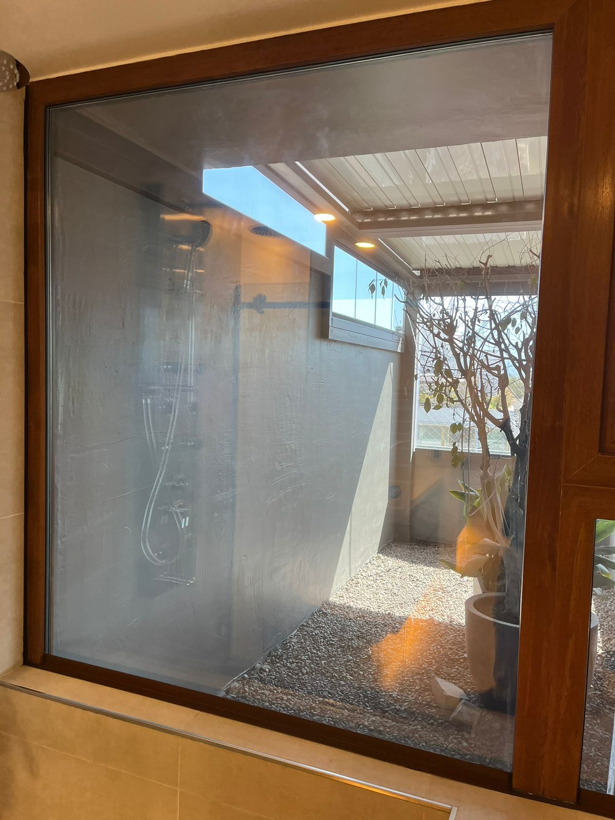 Ventana PVC folio nogal en baño con jardín interior
